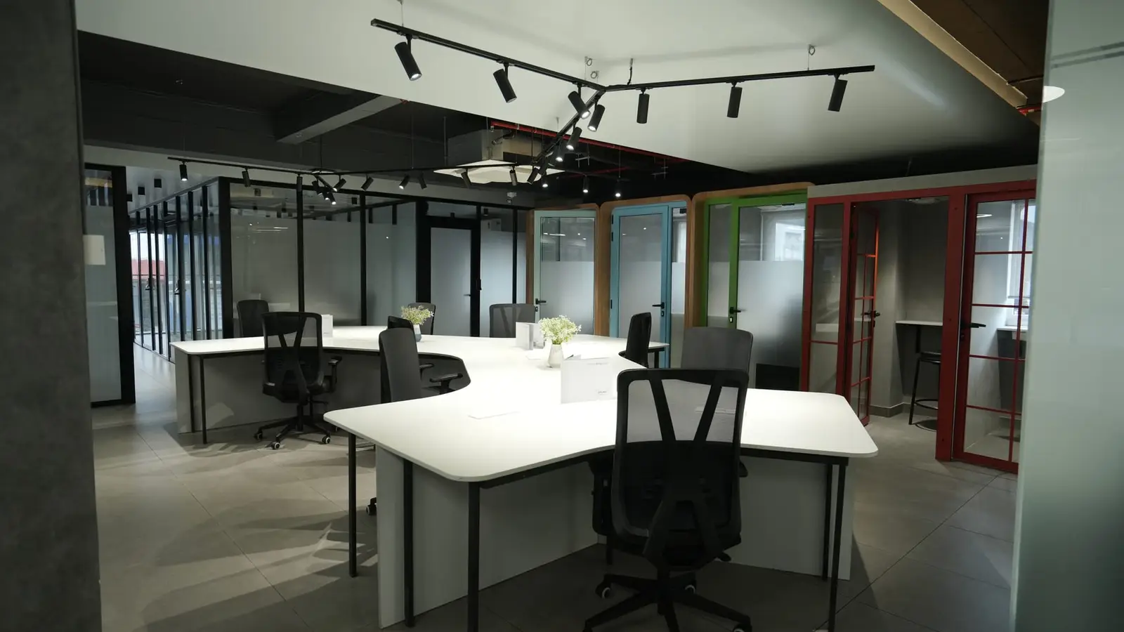 Open coworking floor with colourful phone booths at Spunic Kondotty