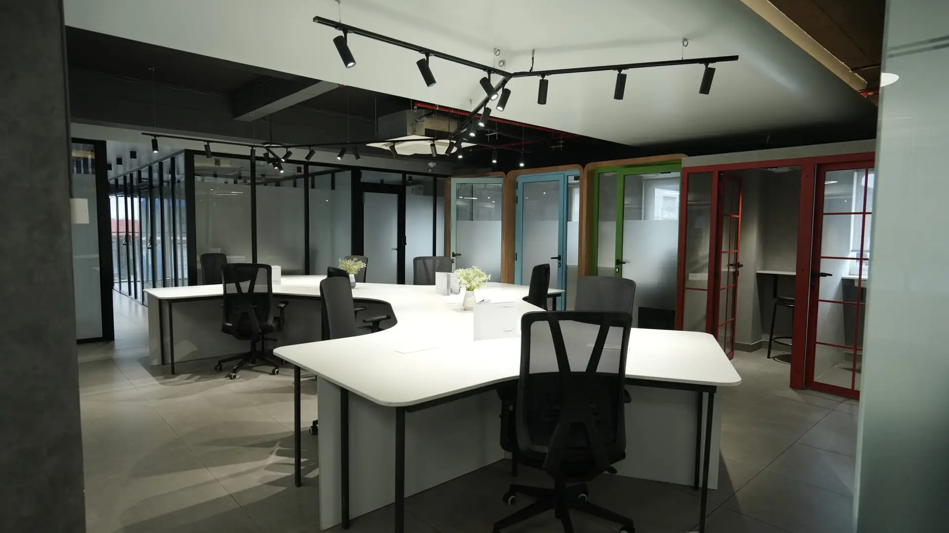 Open coworking floor with colourful phone booths at Spunic Kondotty